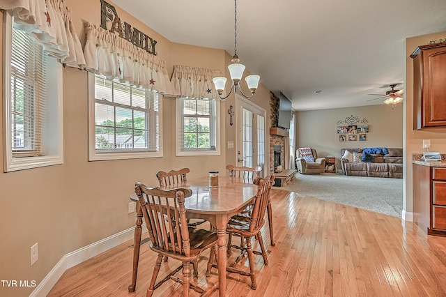 5000 Aberlea Pl, Piney Flats, TN 37686 - dining space with light wood finished floors, a chandelier, a fireplace with raised hearth, and ceiling fan