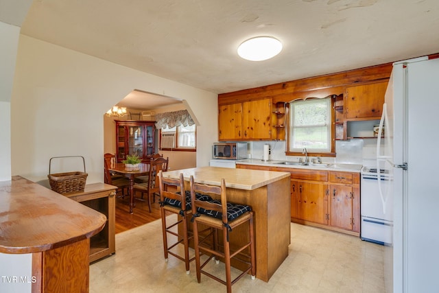 221 Mcfarland Dr, Kingsport, TN 37664 - kitchen with white appliances, light countertops, arched walkways, a kitchen breakfast bar, and light floors