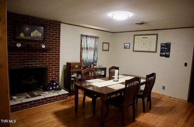 3219 Dungannon Rd, Coeburn, VA 24230 - dining area featuring wood finished floors, crown molding, and a brick fireplace
