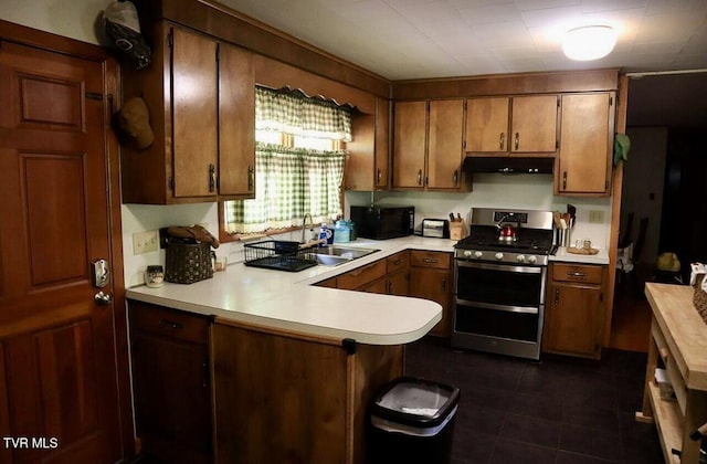 3219 Dungannon Rd, Coeburn, VA 24230 - kitchen with double oven range, under cabinet range hood, light countertops, a peninsula, and brown cabinetry