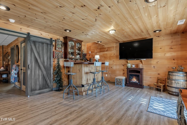 121 Hulse Rd, Jonesborough, TN 37659 - bar area with a barn door, wood finished floors, wooden walls, a lit fireplace, and wooden ceiling