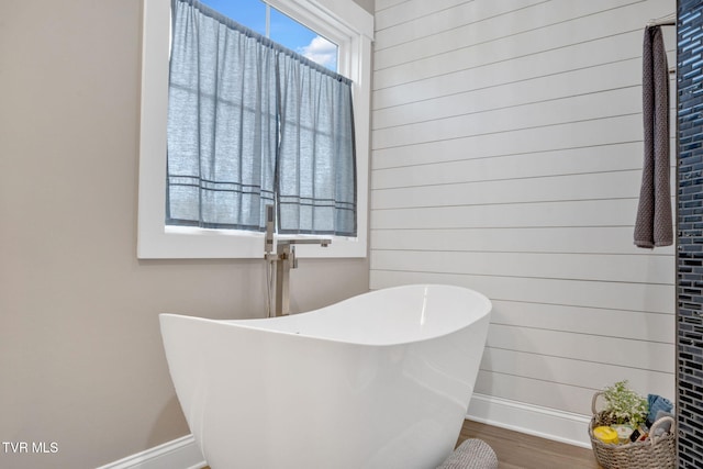 33472 Graceland Ln, Glade Spring, VA 24340 - bathroom featuring a freestanding tub, wood finished floors, and wood walls
