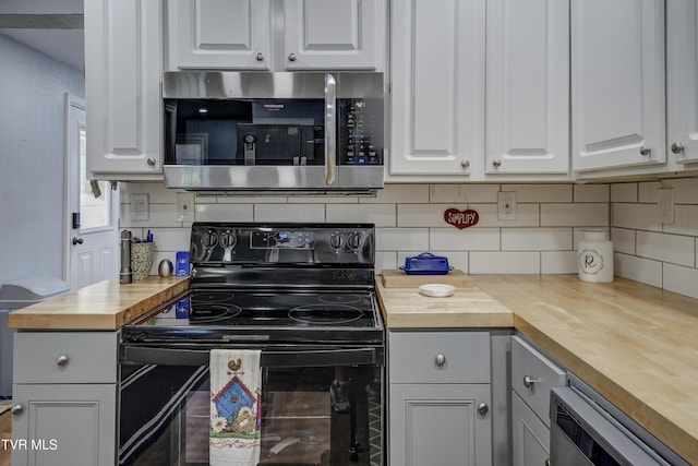 1277 Cooks Valley Rd, Kingsport, TN 37664 - kitchen with butcher block countertops, stainless steel microwave, black / electric stove, and backsplash