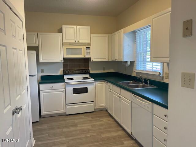 1203 E 8th Ave Unit 3, Johnson City, TN 37601 - kitchen with white appliances, white cabinets, dark countertops, light wood-type flooring, and decorative backsplash
