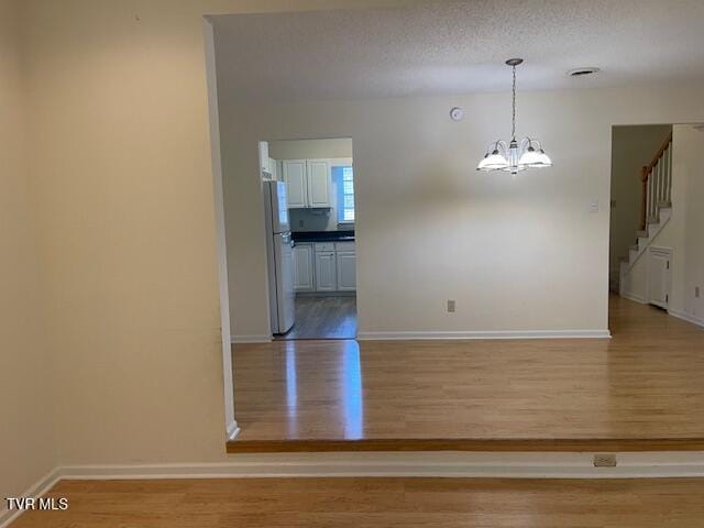 1203 E 8th Ave Unit 3, Johnson City, TN 37601 - unfurnished room with wood finished floors, a chandelier, and stairs
