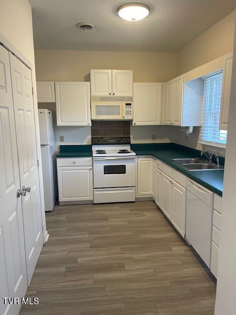 1203 E 8th Ave Unit 3, Johnson City, TN 37601 - kitchen featuring white appliances, white cabinetry, dark countertops, a textured ceiling, and wood finished floors
