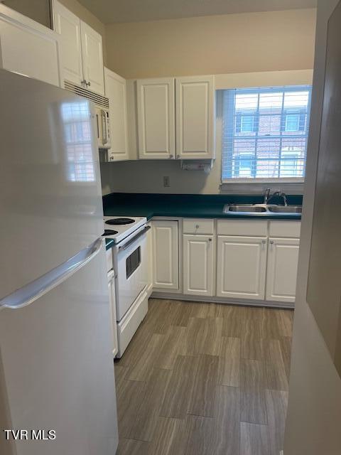 1203 E 8th Ave Unit 3, Johnson City, TN 37601 - kitchen with white appliances, white cabinets, and dark countertops