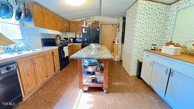 188 Flanary St, Kingsport, TN 37660 - kitchen with black appliances, wallpapered walls, lofted ceiling, light countertops, and a center island