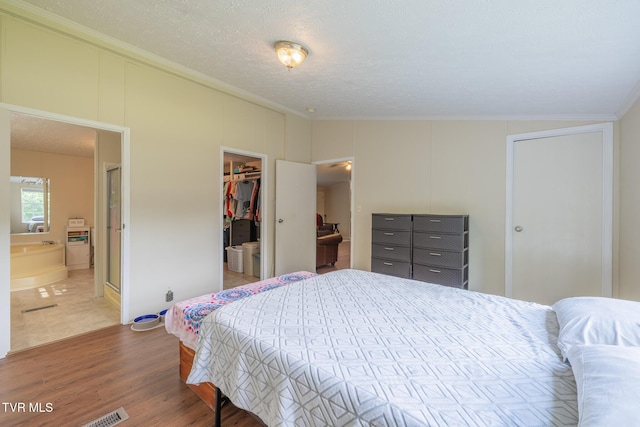 1070 Bill Martin Rd, Afton, TN 37616 - bedroom with ornamental molding, wood finished floors, a walk in closet, a closet, and connected bathroom