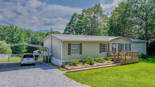 1070 Bill Martin Rd, Afton, TN 37616 - manufactured / mobile home featuring gravel driveway, a detached carport, a deck, and a metal roof