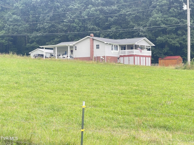 134 Carver Crabtree Rd, Hampton, TN 37658 - view of front facade featuring a shed, a forest view, a front lawn, and a chimney