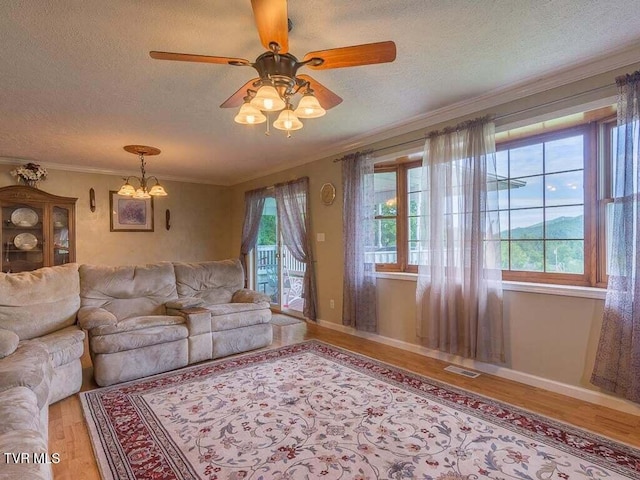 134 Carver Crabtree Rd, Hampton, TN 37658 - living area featuring light wood finished floors, a textured ceiling, a chandelier, crown molding, and ceiling fan