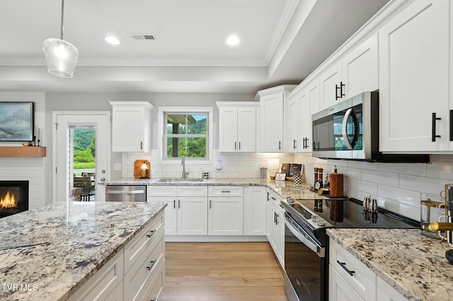 107 Ervin Loop, Erwin, TN 37650 - kitchen with appliances with stainless steel finishes, crown molding, light wood finished floors, decorative backsplash, and white cabinets