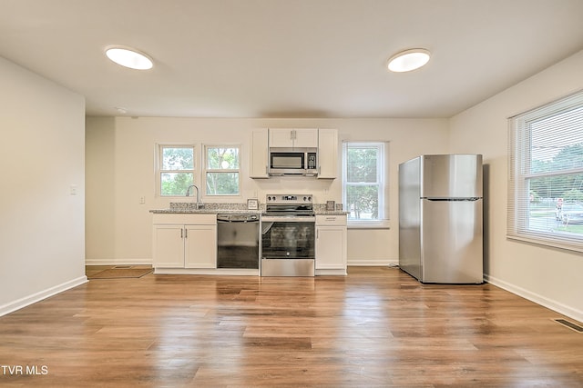 1648 E St, Kingsport, TN 37664 - kitchen featuring stainless steel appliances, plenty of natural light, and white cabinetry