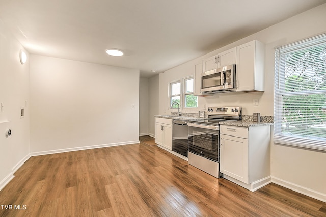 1648 E St, Kingsport, TN 37664 - kitchen with appliances with stainless steel finishes, light wood-type flooring, white cabinetry, and light stone countertops