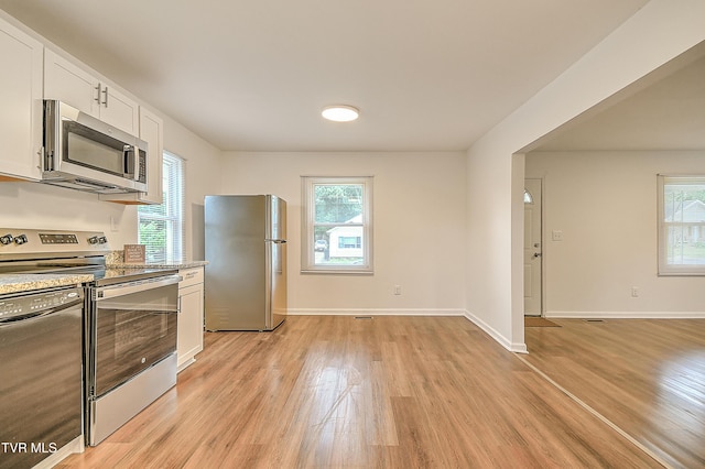1648 E St, Kingsport, TN 37664 - kitchen featuring appliances with stainless steel finishes, light wood-type flooring, white cabinets, and light stone countertops