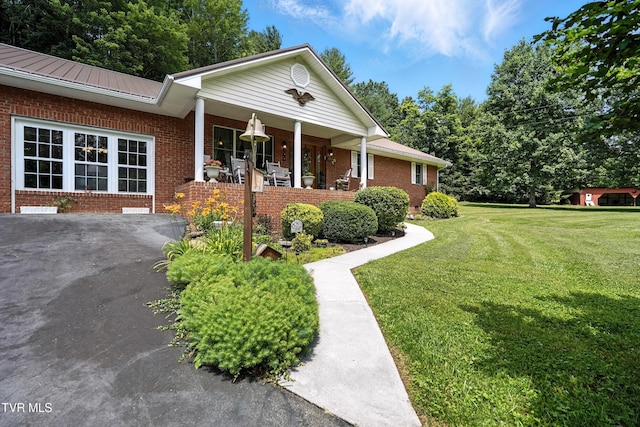 1037 Swift Hollow Rd, Mountain City, TN 37683 - view of front facade with brick siding, covered porch, a front yard, and a metal roof