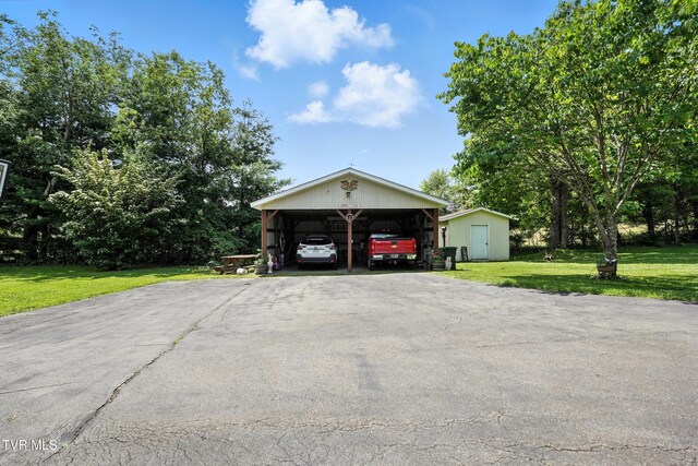 1037 Swift Hollow Rd, Mountain City, TN 37683 - garage featuring asphalt driveway, a detached carport, and a shed