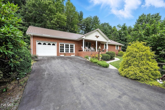 1037 Swift Hollow Rd, Mountain City, TN 37683 - view of front facade featuring brick siding, a porch, an attached garage, asphalt driveway, and a metal roof