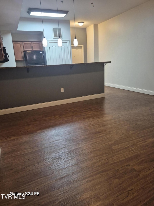 116 Tipton St Unit 209, Johnson City, TN 37604 - kitchen with dark countertops, freestanding refrigerator, a kitchen breakfast bar, and pendant lighting