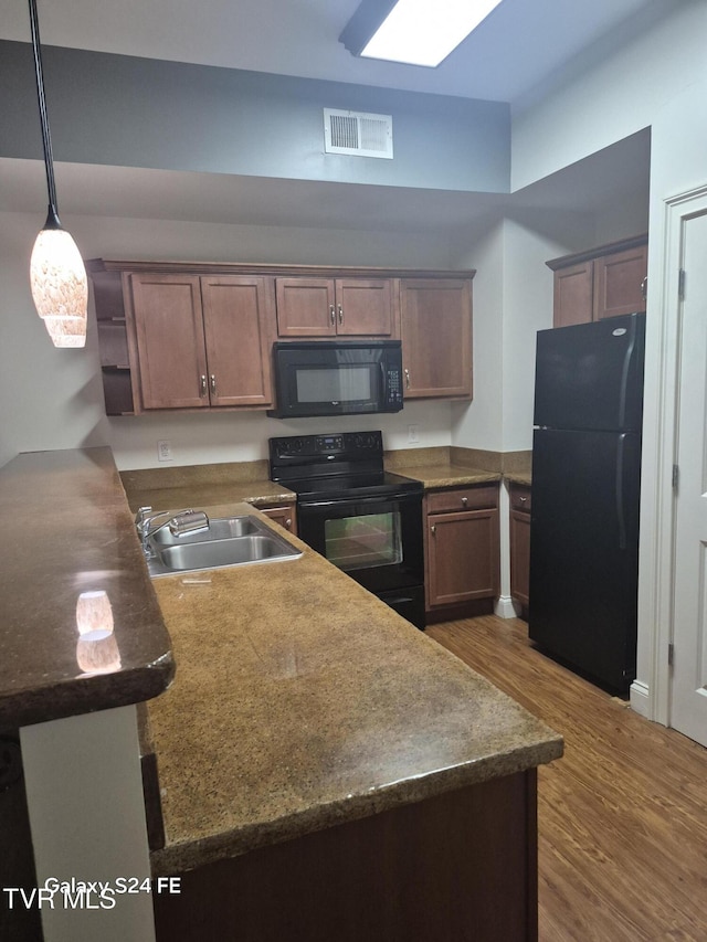 116 Tipton St Unit 209, Johnson City, TN 37604 - kitchen featuring black appliances, wood finished floors, open shelves, and dark countertops