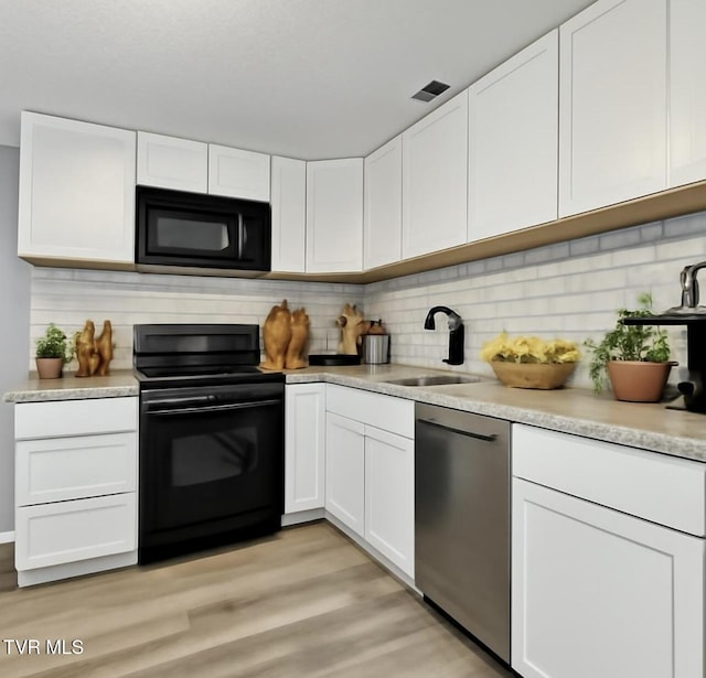 3974 Memorial Blvd, Kingsport, TN 37664 - kitchen with black appliances, light wood finished floors, and white cabinets