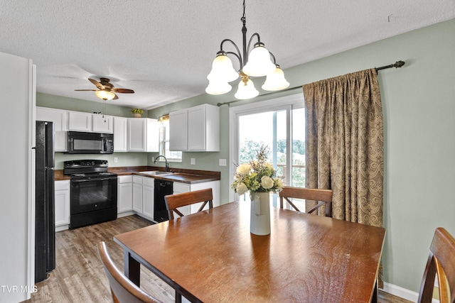 3500 Old Stage Rd, Chuckey, TN 37641 - kitchen featuring black appliances, a chandelier, a textured ceiling, white cabinetry, and light wood-type flooring