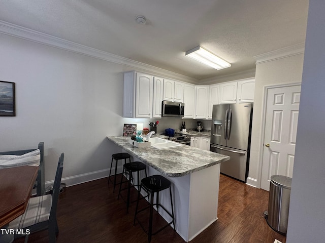 700 NW The Terrace St Unit D, Norton, VA 24273 - kitchen with stainless steel appliances, a peninsula, a breakfast bar, ornamental molding, and white cabinets