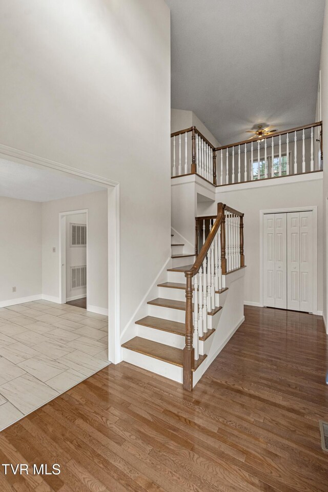 945 Dashaway Rd, Chuckey, TN 37641 - stairway featuring a ceiling fan, a towering ceiling, and wood finished floors