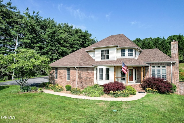 945 Dashaway Rd, Chuckey, TN 37641 - traditional home with a porch, brick siding, a front yard, and roof with shingles