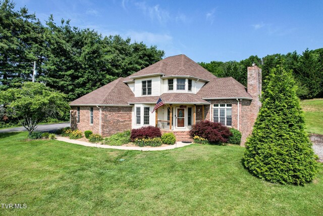 945 Dashaway Rd, Chuckey, TN 37641 - view of front of house with brick siding, a chimney, a front lawn, and roof with shingles