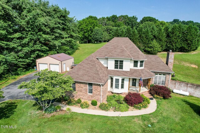 945 Dashaway Rd, Chuckey, TN 37641 - view of front facade with an outbuilding, a detached garage, brick siding, a chimney, and a front yard