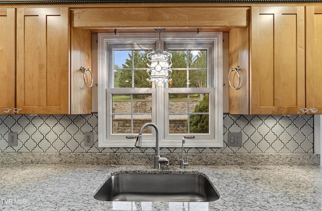 945 Dashaway Rd, Chuckey, TN 37641 - kitchen featuring tasteful backsplash, light stone countertops, hanging light fixtures, and brown cabinetry