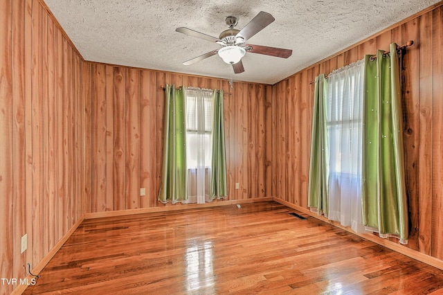 307 Tween Hills Rd, Bristol, TN 37620 - unfurnished room featuring wood finished floors, wood walls, ceiling fan, and a textured ceiling