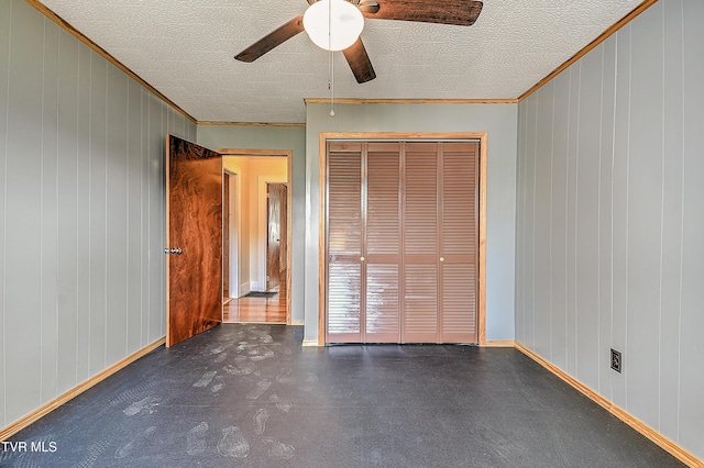 307 Tween Hills Rd, Bristol, TN 37620 - unfurnished bedroom featuring crown molding, a textured ceiling, a closet, a ceiling fan, and wooden walls