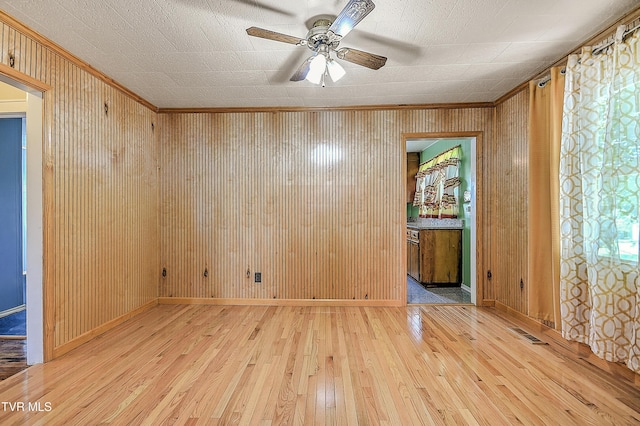 307 Tween Hills Rd, Bristol, TN 37620 - spare room with light wood-style flooring, ornamental molding, a ceiling fan, and wood walls