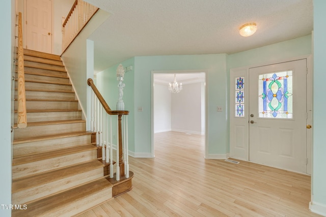 256 S Creek Ct, Kingsport, TN 37663 - entrance foyer featuring stairs, light wood-type flooring, a chandelier, and a textured ceiling