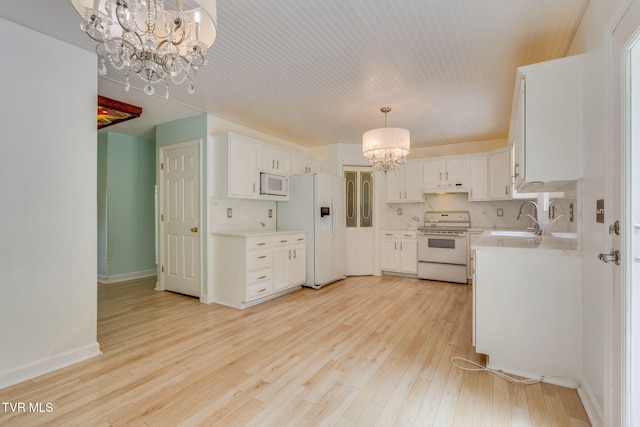 256 S Creek Ct, Kingsport, TN 37663 - kitchen with a chandelier, white appliances, under cabinet range hood, light countertops, and light wood finished floors