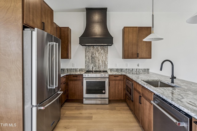 1533 Pactolas Rd Unit 107, Johnson City, TN 37604 - kitchen featuring premium appliances, range hood, light stone countertops, and light wood finished floors