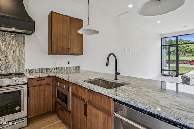1533 Pactolas Rd Unit 107, Johnson City, TN 37604 - kitchen with ventilation hood, appliances with stainless steel finishes, light stone countertops, hanging light fixtures, and light wood-style floors