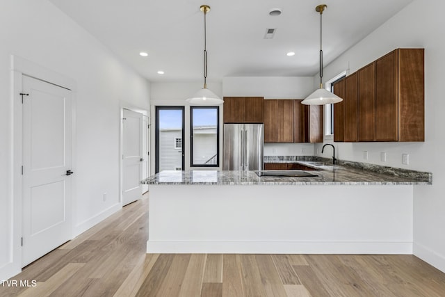 1533 Pactolas Rd Unit 107, Johnson City, TN 37604 - kitchen featuring freestanding refrigerator, light stone countertops, light wood finished floors, a peninsula, and recessed lighting