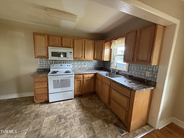 609 W D St, Elizabethton, TN 37643 - kitchen featuring white appliances, decorative backsplash, dark countertops, and stone finish floors