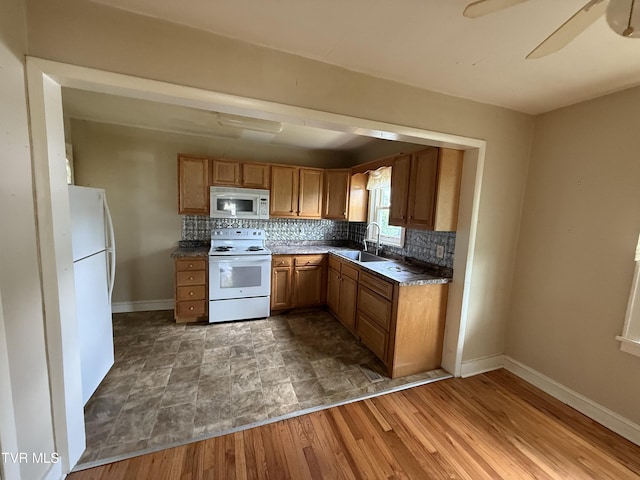 609 W D St, Elizabethton, TN 37643 - kitchen featuring white appliances, decorative backsplash, brown cabinets, dark countertops, and ceiling fan