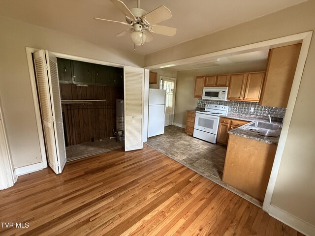 609 W D St, Elizabethton, TN 37643 - kitchen with white appliances, a ceiling fan, wood finished floors, backsplash, and gas water heater