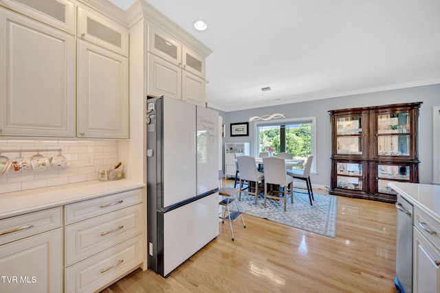 788 Watauga Rd, Watauga, TN 37694 - kitchen with freestanding refrigerator, tasteful backsplash, light countertops, light wood-style floors, and crown molding
