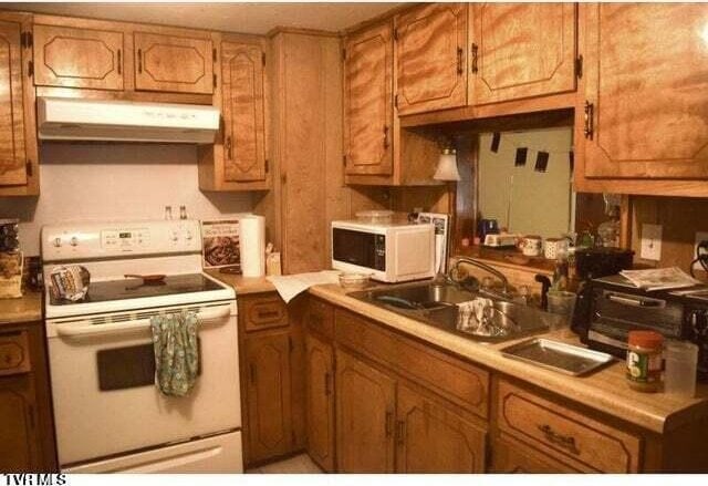 500 Guy Lloyd Rd, Erwin, TN 37650 - kitchen with white appliances, under cabinet range hood, light countertops, and brown cabinets