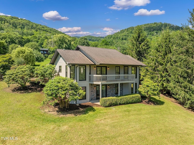 119 Orchard Meadows Ln, Roan Mountain, TN 37687 - view of front of house with stone siding, a front lawn, a balcony, and a forest view