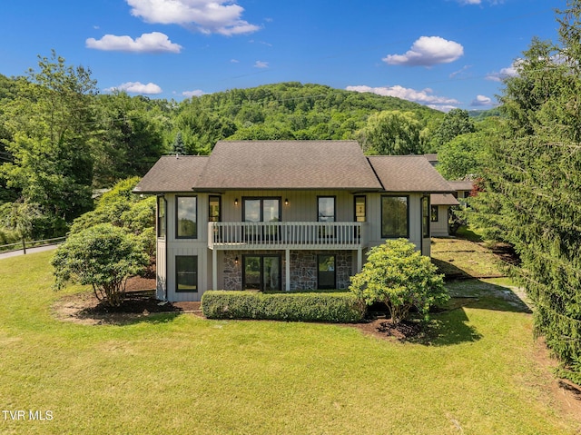 119 Orchard Meadows Ln, Roan Mountain, TN 37687 - view of front of property featuring a wooded view, roof with shingles, a front yard, stone siding, and a balcony