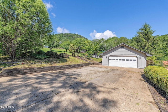 119 Orchard Meadows Ln, Roan Mountain, TN 37687 - view of property exterior featuring a detached garage, an outdoor structure, and a forest view