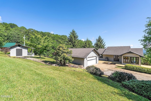 119 Orchard Meadows Ln, Roan Mountain, TN 37687 - ranch-style house with a garage, concrete driveway, a storage unit, and a front yard